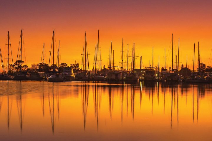 Docked boats in Yamba against a sunrise background